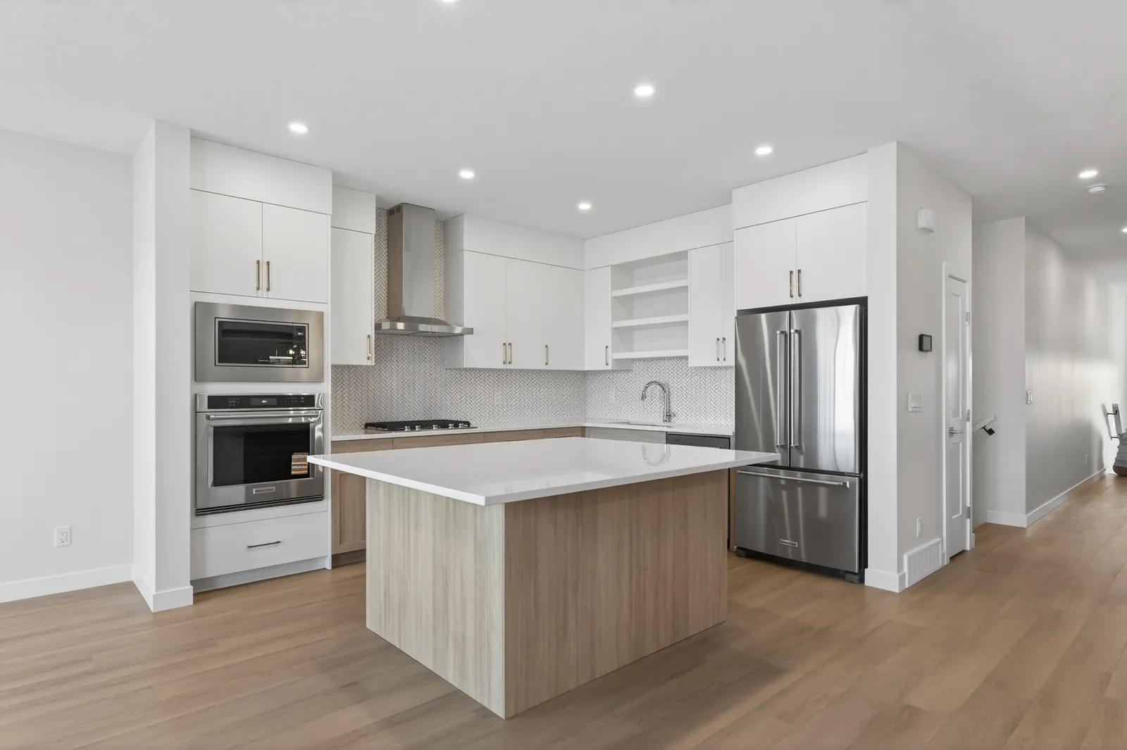 The chef-inspired kitchen at 159 Greenwich Drive NW, with warm woodgrain cabinets and quartz counters.